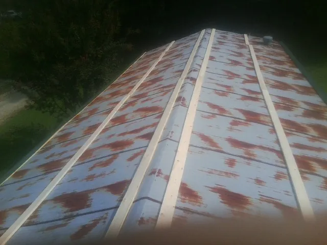 Rusted metal roof panels with new wood purlins before replacement — Storm Damage Roof Repair in Colorado City by Roofing Brothers